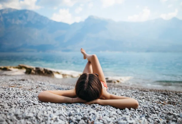 Mujer acostada en la playa de guijarros — Foto de Stock