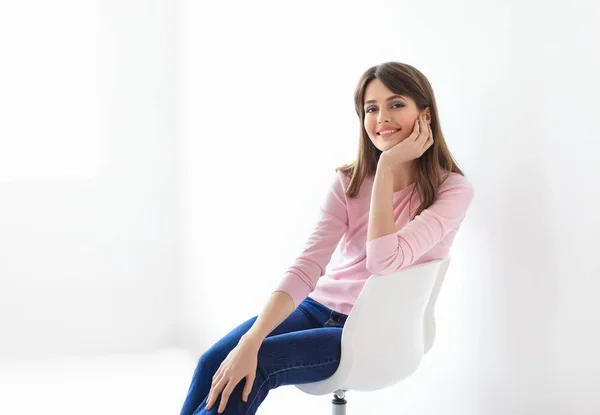 Mulher feliz sentada na cadeira — Fotografia de Stock