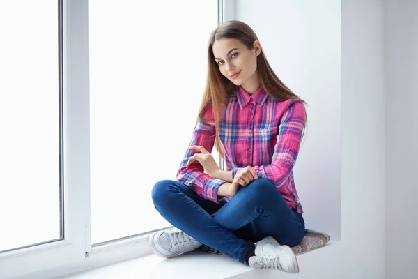 Frau entspannt auf Fensterbank — Stockfoto