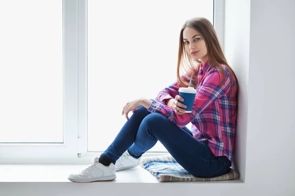 Woman relaxing on window sill — Stock Photo, Image