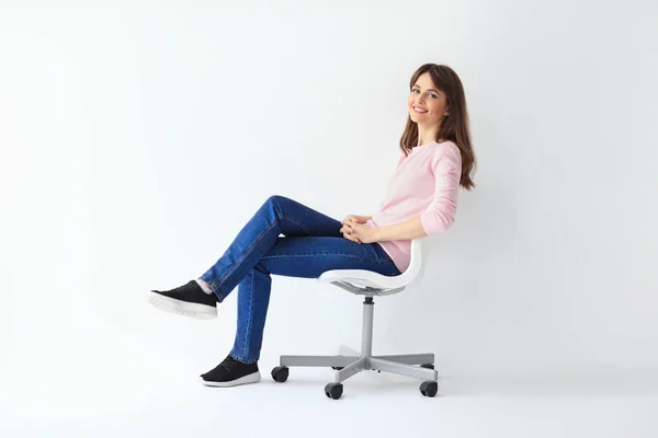 Счастливая женщина сидит на стуле Лицензионные Стоковые Изображения