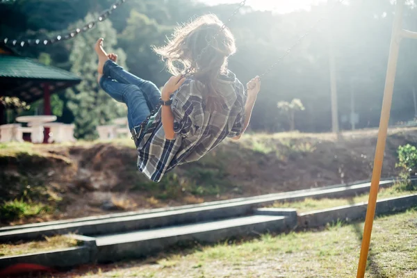 Barefoot young woman swinging — Stock Photo, Image