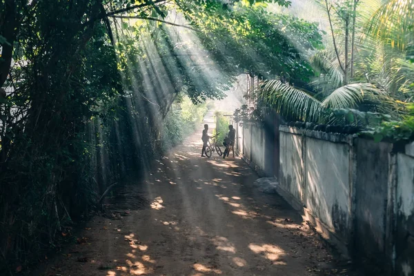 Dwoje dzieci z rowerami w sunrays — Zdjęcie stockowe