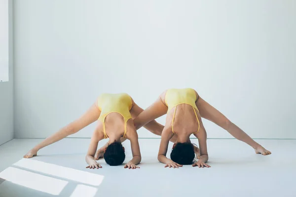 Duas jovens mulheres fazendo ioga asana — Fotografia de Stock