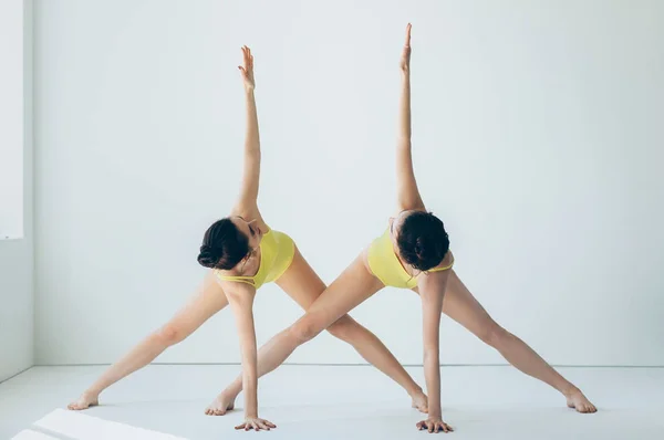 Dos mujeres hermosas jóvenes haciendo yoga asana — Foto de Stock