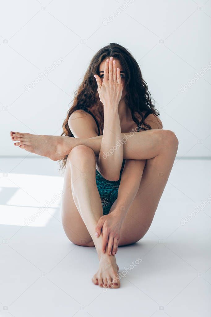 Young beautiful dancer close face with hand 