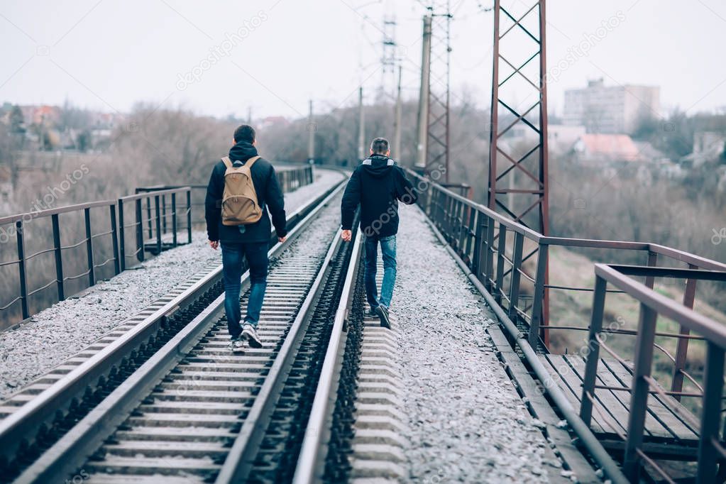 men walking away on railroad