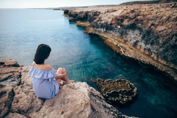 Cape Greco oturan genç kadın — Stok fotoğraf