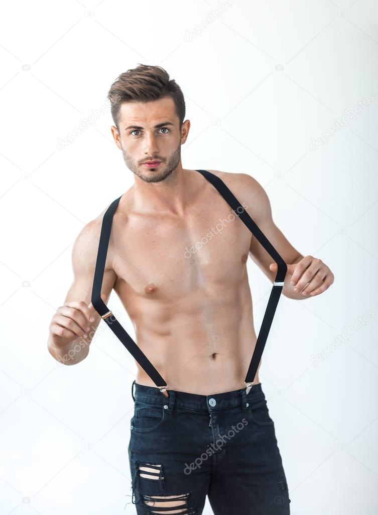 shirtless young man in suspenders