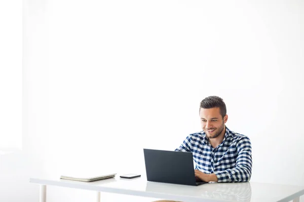 Hombre sonriente escribiendo en el ordenador portátil — Foto de Stock