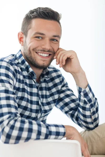 Knappe Glimlachende man zit op stoel — Stockfoto