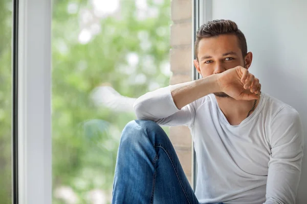 Man zit op de vensterbank — Stockfoto