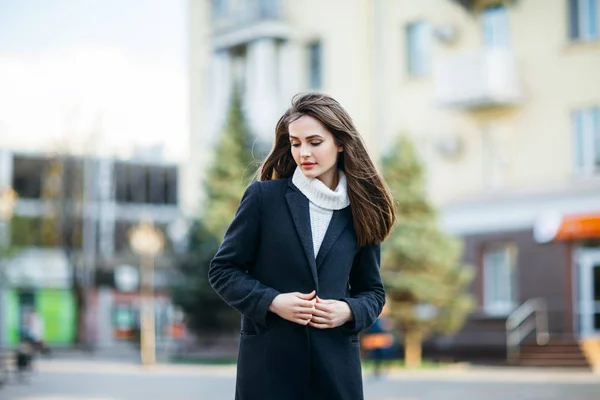 Застенчивая женщина стоит на городской улице — стоковое фото