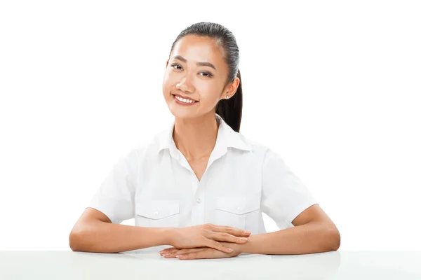 Menina asiática em camisa branca sentada à mesa — Fotografia de Stock