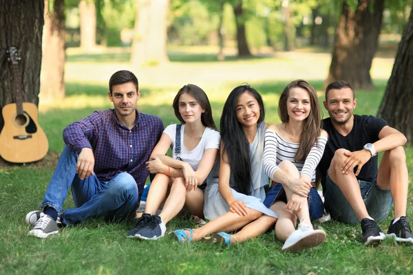 Grupo de amigos sentados no parque — Fotografia de Stock