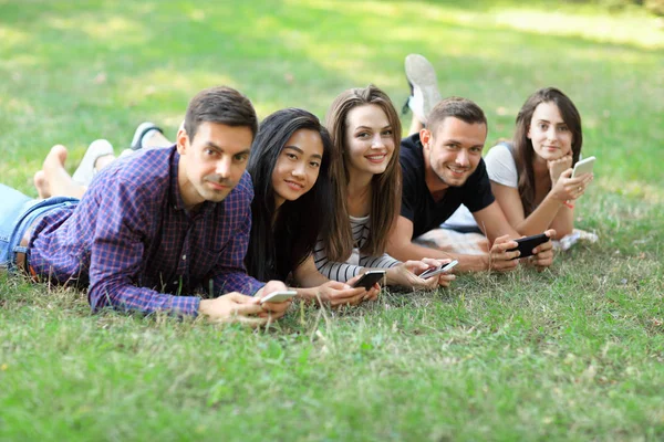 Unga vänner använda mobiltelefoner — Stockfoto