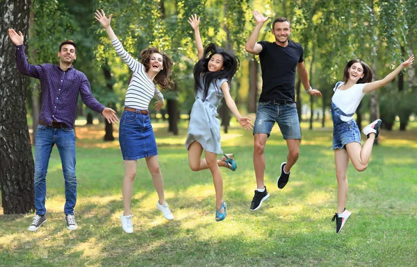 Cinco amigos felizes pulando ao ar livre — Fotografia de Stock