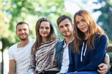 bankta oturan genç arkadaşlar