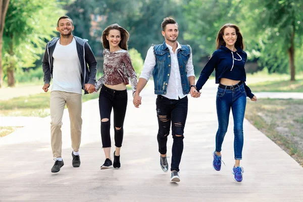 Giovani amici che camminano nel parco — Foto Stock