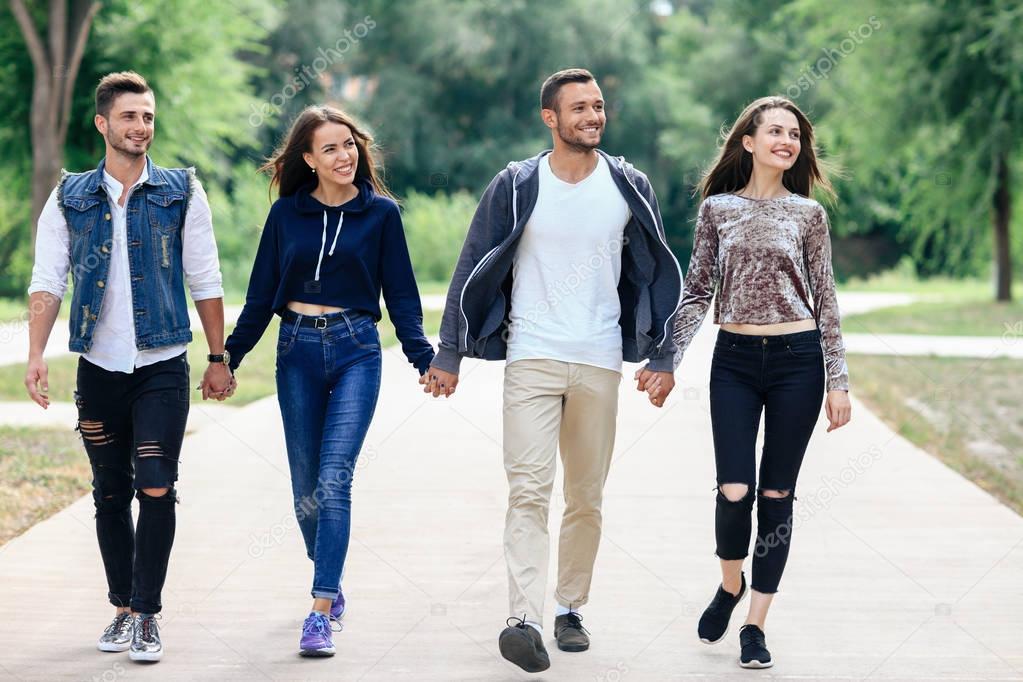 young friends walking in park