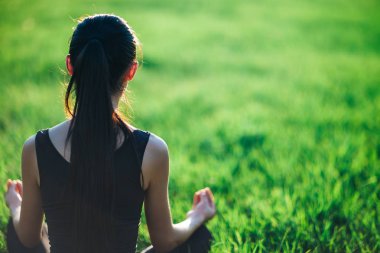 genç kadın çimenlerin üzerinde meditasyon