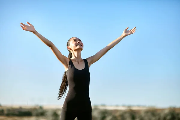 Frau in Sportkleidung steht mit offenen Armen — Stockfoto