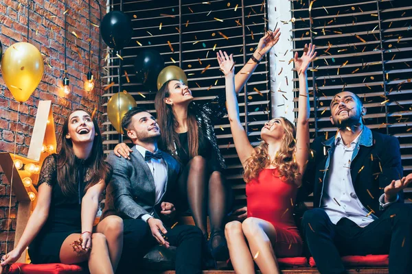 Vrienden gooien van confetti op feestje — Stockfoto