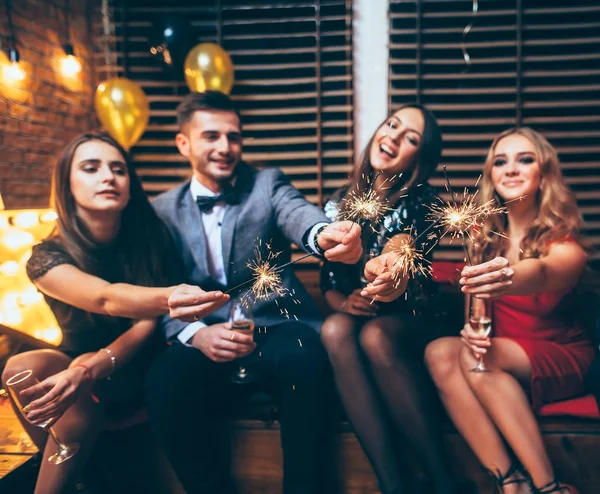 Friends holding sparklers at club — Stock Photo, Image