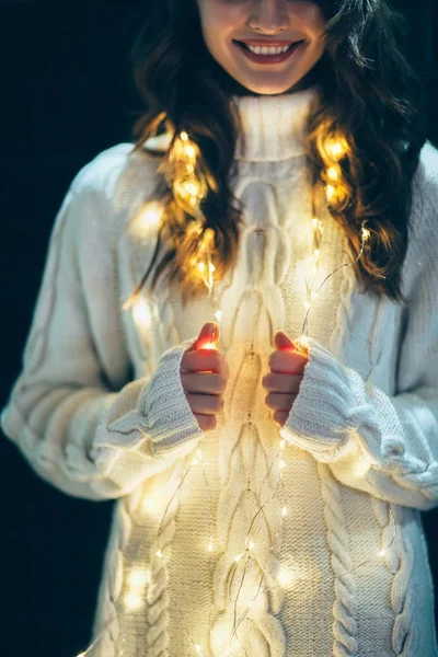 Женщина, завернутая в рождественские огни — стоковое фото