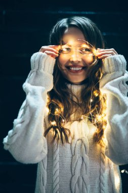Noel ışıkları içinde sarılı kadın 