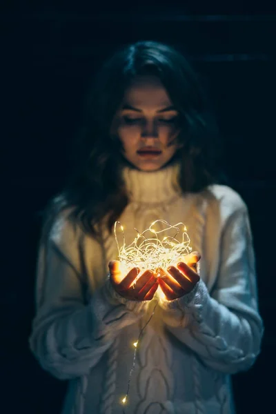 Mujer sosteniendo luces de Navidad en las manos —  Fotos de Stock