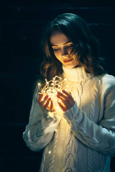 Mulher segurando luzes de Natal nas mãos — Fotografia de Stock