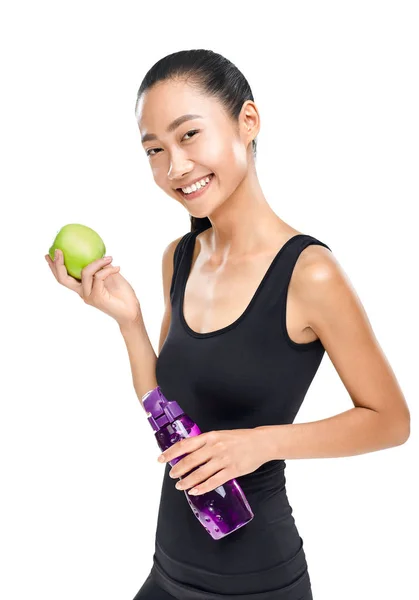 微笑的年轻亚洲运动员藏品 Sipper 瓶和绿色苹果在白色背景隔绝了 — 图库照片