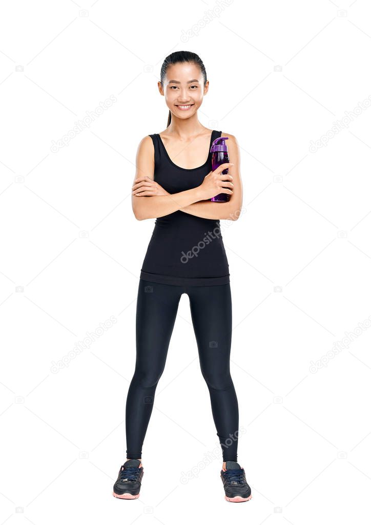 Smiling young Asian athlete standing confidently and holding sipper bottle isolated on white background
