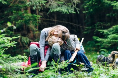 Sarılma çocuk orman glade, başlarını eğik oturuyor. Kız ve erkek kardeşim ağaçlar köpek ile çevrili açıklıkta oynuyorlar. Aile bağları 