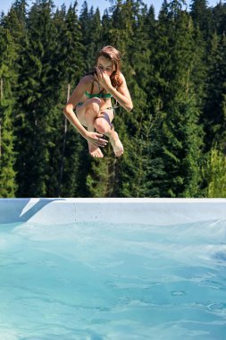 Kız havuz içine, burun tutan atlar. Çocuklar açık havada su dalış. Doğa ve pitoresk doğal peyzaj etkin boş