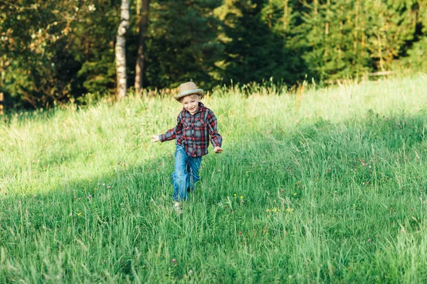 夏の草原を走っていた少年幸せな子 陽気な休暇の田舎で — ストック写真