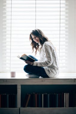 Kitap okuyan güzel bir kadın. 