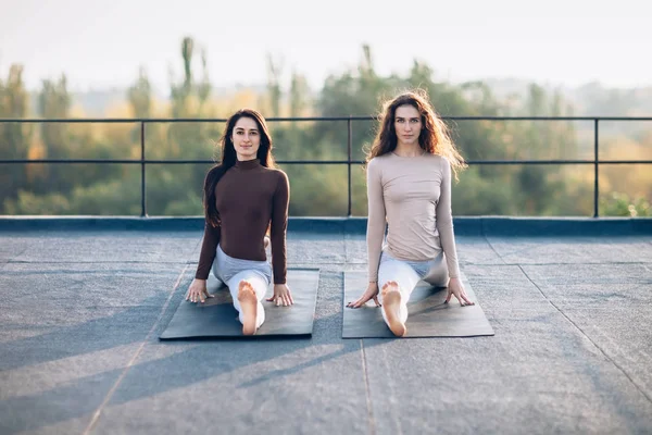 Mulheres sentadas em um hanumanasana — Fotografia de Stock