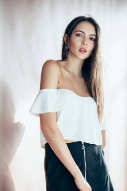 Genç kadın stüdyo ışık arka plan üzerinde poz