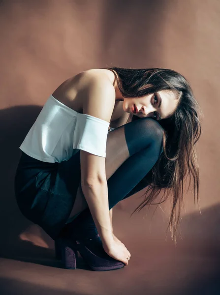 Mujer Joven Posando Sobre Fondo Marrón Sentada Cuclillas — Foto de Stock