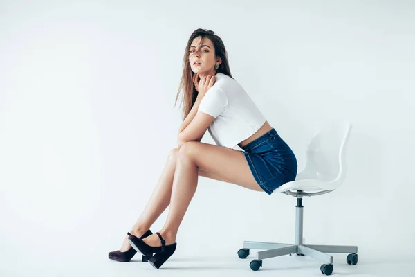 Junge Frau Sitzt Auf Stuhl Auf Weißem Hintergrund — Stockfoto