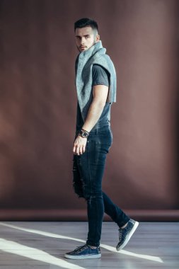 Yürüyüş ve kameraya bakarak şık yakışıklı yan görünüm