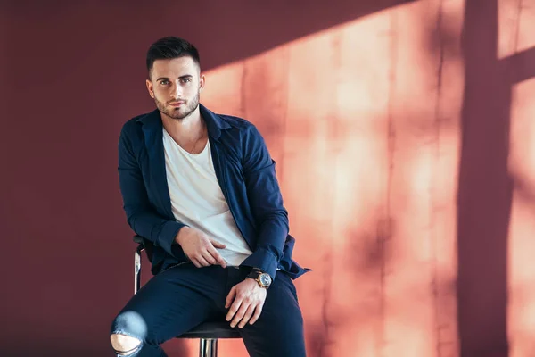 Portrait Confident Handsome Man Sitting Chair Copy Space Red Wall — Stock Photo, Image