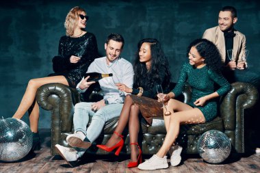 Çeşitli arkadaş grupları eğleniyor, eğleniyor ve şampanya dolduruyor.