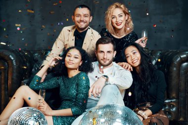 Çeşitli mutlu genç arkadaşlar eğleniyor, eğleniyor ve şampanya içiyor.