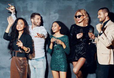 Bir grup genç gece kulübünde dans ediyor, eğleniyor ve eğleniyorlar.