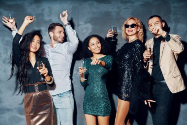 Bir grup genç gece kulübünde dans ediyor, eğleniyor ve eğleniyorlar.