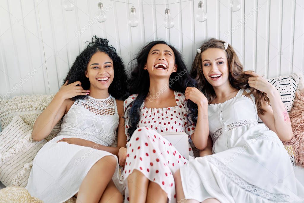 Laughing happy women have fun relax together at home. Multi ethnic females friendship concept                     