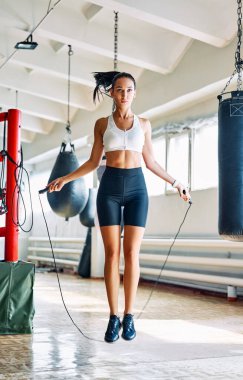 Spor salonunda ip atlayan güzel bir fitness kadını. Kardiyo ve fitness egzersizi. Spor konsepti           